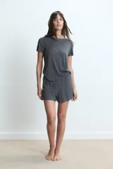 Conjunto de pijama de dos piezas, color gris oscuro, con estampado de pequeños motivos blancos. Incluye una remera de manga corta y un short.