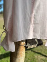 Camisa oversize a rayas verticales rosas y blancas, con cuello mao y manga larga.