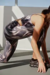 Calza deportiva 7/8 estampada en tonos grises y marrones, con cintura alta y corte ajustado.
