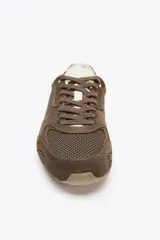 Zapatillas deportivas marrones con detalles en gamuza y malla, cordones marrones y suela beige.