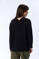 Blusa negra de manga larga con escote en V y cierre frontal con botones.