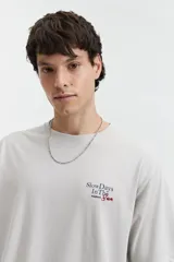 Remera gris de manga corta con cuello redondo y estampado en el pecho con la frase "Slow Days In The Sun".