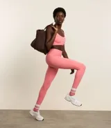 Calza deportiva larga color rosado, de microfibra pesada, sin estampa y con tiras elásticas cruzadas en la espalda.