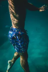 Short de baño azul con estampado floral, elástico en la cintura, tres bolsillos (dos laterales y uno trasero), tela de secado rápido con doble costura de seguridad e interior con mesh hipoalergénico.