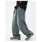 Pantalón de jean de corte ancho y tiro alto, color celeste desgastado. Presenta costuras decorativas en contraste, paneles superpuestos en las rodillas y cordón de ajuste blanco en la cintura elástica.