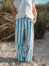 Pantalón wide leg a rayas verticales azules y blancas, con cintura alta y lazo ajustable.
