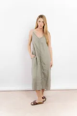 Vestido largo de lino color verde oliva, con breteles finos y detalle de volados verticales en el centro y los laterales.