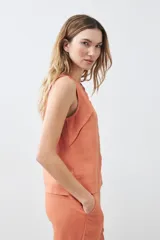 Blusa sin mangas color durazno, confeccionada en lino con efecto desflecado.