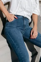 Pantalón de jean acampanado color marrón, con tiro alto, alforza central y ruedo desflecado.