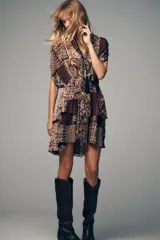 Vestido corto con estampado de cachemira en tonos marrones, beige y verde. Tiene escote en pico con abalorios, mangas cortas y cintura elástica con cinturón fino.