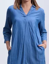 Vestido corto azul de tencel con cuello solapa y escote en V. Manga 3/4 regulable con presilla y botón.