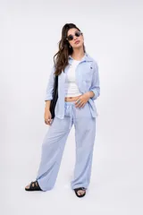 Camisa a rayas verticales color beige y blanco, con cuello clásico, cierre frontal con botones y mangas largas.