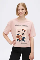 Remera rosa con estampado de flores y texto en francés.