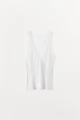 Musculosa blanca de algodón con escote en V y tirantes anchos. Tejido de punto calado en la parte superior y tejido de punto acanalado en la parte inferior.
