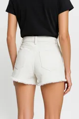 Short de jean color beige, tiro alto, con bolsillos delanteros y traseros, roturas y ruedo desflecado.