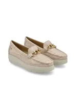 Mocasín de cuero charol negro con plataforma blanca y detalle de hebilla metálica plateada en el empeine.