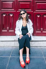 Bailarinas de piel bicolor, con pulsera y múltiples calados. La parte delantera lleva una rejilla transparente roja. La punta y el talón son de terciopelo de seda negro con lunares rojos.