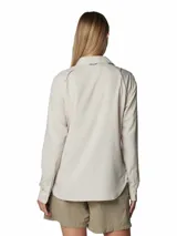 Camisa de manga larga color beige claro, con cuello clásico, cierre frontal con botones y dos bolsillos en el pecho. Confeccionada con tejido transpirable con protección solar FPS 50 y tecnología Omni-Wick™ para absorción de la humedad.
