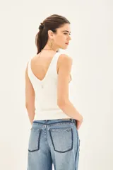 Musculosa blanca tejida en hilado de algodón, con escote en V pronunciado y calce al cuerpo.