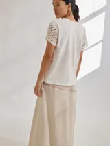 Falda midi color crudo de algodón, con pespuntes rojos a contratono y botones de coco en el lateral.