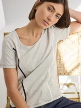 Remera gris de algodón y spandex, de manga corta y cuello redondo. Presenta líneas verticales en blanco y negro. Corte recto.