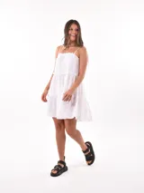 Vestido corto blanco con tirantes finos ajustables y falda escalonada con volados.