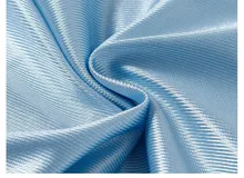 Remera estilo jersey de fútbol o americana, color celeste claro, con paneles de tela satinada y malla microperforada. Presenta cuello en V con ribete blanco, el número "90" grande en el frente con borde negro, y texto en la parte superior que dice "BAEN MADE" y "Madcapsclub".