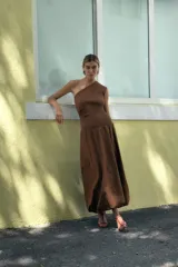 Vestido midi color marrón de escote asimétrico con manga sisa, con cuerpo superior de tejido de punto acanalado y falda globo con bolsillos laterales de plastrón con solapa. 