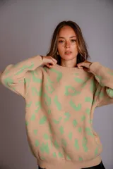 Sweater de punto color crudo con estampado animal print marrón.