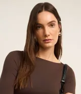 Blusa negra de poliamida con escote barco y mangas largas.