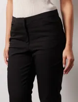 Pantalón capri negro de algodón con terminación de ruedo con aplique calado.