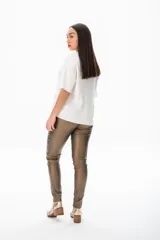 Remera blanca de viscosa con cuello redondo decorado con apliques plateados y mangas cortas amplias.