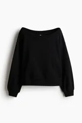 Buzo negro con escote off-the-shoulder, hombros caídos, corte holgado y mangas largas con puños acanalados.