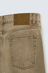 Pantalón de jean color marrón claro, de corte recto y tiro alto, con cinco bolsillos y cierre frontal con botones.