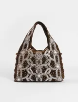 Bolso de mano tipo hobo o baguette de gamuza marrón oscuro, completamente cubierto con un intrincado diseño de flores y patrones geométricos hechos con lentejuelas plateadas y pequeños apliques brillantes. Los bordes laterales están decorados con cuentas de madera marrón.