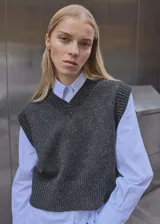 Chaleco de punto gris con cuello en pico y diseño sin mangas.
