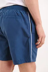 Short de baño azul marino con cintura elástica y cordón ajustable. Detalle de ribete blanco en el lateral.