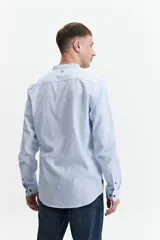 Camisa azul de manga larga con cuello mao y cartera abotonada.