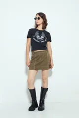 Falda corta tipo cargo de tiro medio, color negro, con costuras visibles en contraste blanco y bolsillos aplicados.