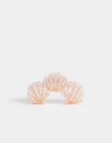 Broche para el pelo con forma de caracola color rosa claro con lunares blancos y detalles dorados.