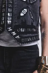Chaleco negro de jean con bordados y apliques plateados.