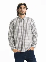 Camisa celeste y blanca a rayas verticales, de manga larga y corte clásico. Tiene cuello abotonado y bolsillo en el pecho.