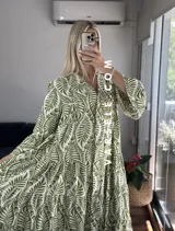 Vestido largo marrón con estampado de hojas, cuello camisero, mangas largas y corte escalonado.