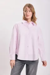 Camisa manga larga oxford a rayas verticales rosas y blancas, con cuello clásico, cierre frontal con botones y bolsillo de parche en el pecho.