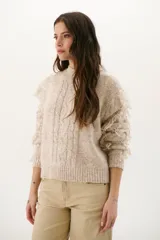 Sweater color arena de tejido de punto con cuello redondo y mangas largas con flecos.