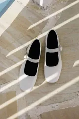 Zapato estilo Mary Jane color marrón, de cuero, con punta redondeada y tira sobre el empeine con hebilla.