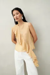 Top color durazno de tencel sin mangas, de corte asimétrico y volados.
