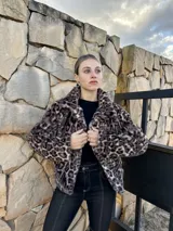 Chaqueta corta de gamulán sintético con estampado animal print, cuello solapa y cierre frontal con botones dorados.