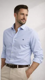 Camisa de manga larga color azul claro, con cuello abotonado y un pequeño logo bordado en el pecho.