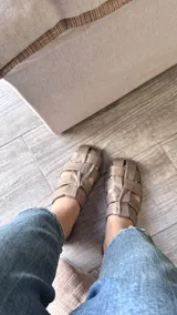 Sandalias bajas color rosa viejo con tiras de cuero entrelazadas y suela marrón.